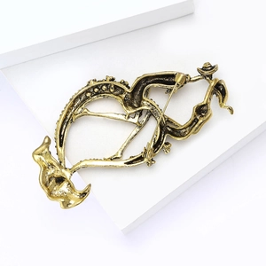 Detail view of vintage gold alloy brooch featuring abstract floral texture and safety pin