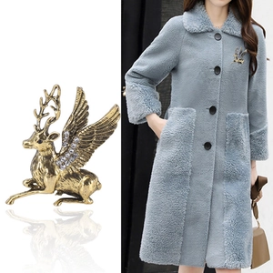 Luxurious golden elk deer brooch with wings and clear crystals on gray wool coat