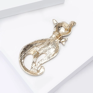 Détail du dos de la broche chat en émail doré montrant le fermoir et la texture du métal