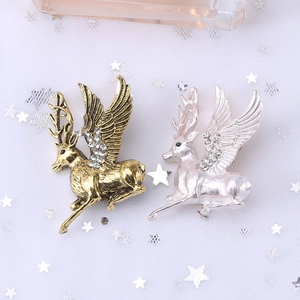 Golden and pearl white flying reindeer brooches with sparkling crystal wings on mesh