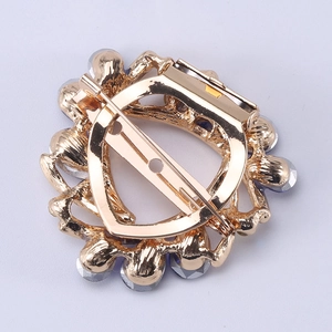 Back view of vintage sunflower brooch in gold alloy with blue crystals and pin closure