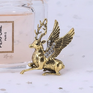 Detailed close-up of golden reindeer brooch with wings and sparkling rhinestones