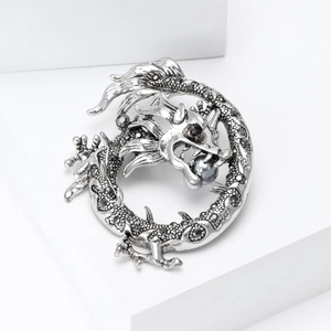 Détail macro de broche dragon en argent vintage avec cristaux noirs et perle