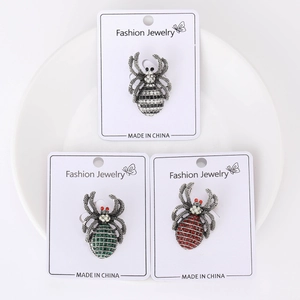 Detailed view of three vintage spider brooches with rhinestones on a white plate