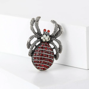 Detail of vintage spider brooch with red rhinestones and silver alloy gothic texture