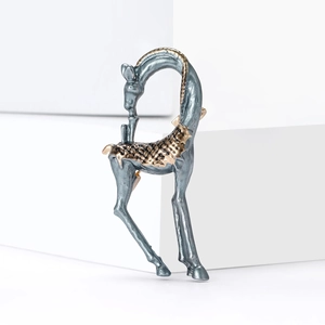 Elegant silver and gold giraffe brooch with vintage metallic texture on a white background