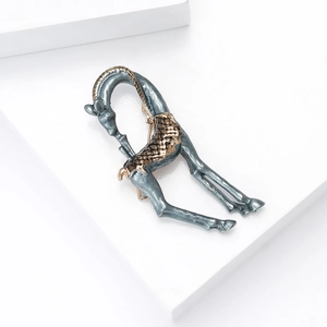 Detail of giraffe brooch with grey-blue enamel and golden finish on white background