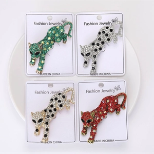 Dettaglio ravvicinato di spille a forma di leopardo fatte a mano con strass colorati