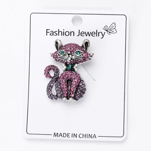 Macro detail of cat brooch with pink and purple rhinestones on silver metal base