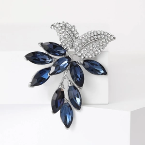 Elegant silver leaf brooch featuring deep blue crystals and shimmering white rhinestones