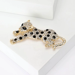 Dettaglio di una spilla a forma di leopardo dorata fatta a mano con strass bianchi