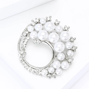 Detailed close-up of a silver wreath brooch with faux pearls and sparkling rhinestones
