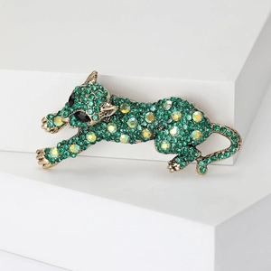 Dettaglio della spilla a forma di leopardo con strass verdi e placcatura oro