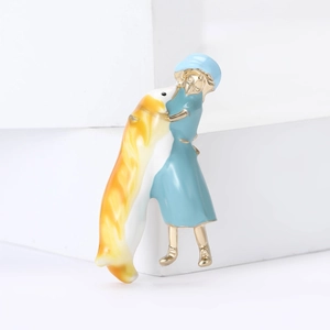 Broche de esmalte de niña en vestido azul abrazando pez dorado sobre base blanca