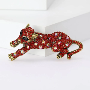 Dettaglio ravvicinato di una spilla a leopardo con strass rossi e finitura dorata
