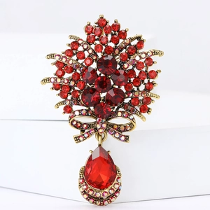 Broche bouquet vintage avec cristaux rouges et pendentif goutte sur socle blanc