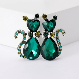 Macro detail of cat brooch featuring deep green teardrop crystals and pavé rhinestones