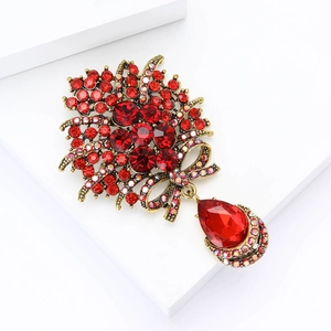 Détail d'une broche vintage bouquet avec cristaux rouges et pendentif en goutte