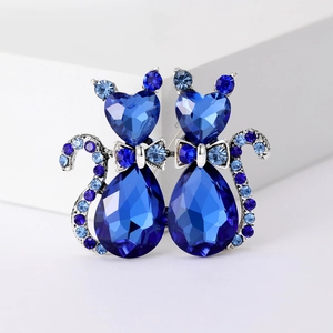 Elegant silver brooch with dual blue crystal cats and heart-shaped gemstone accents
