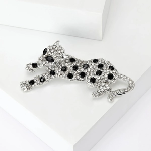 Dettaglio ravvicinato di una spilla a forma di leopardo con strass bianchi e neri