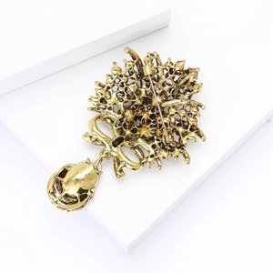 Détail de la broche fleur dorée vintage montrant l'épingle sécurisée et le travail du métal