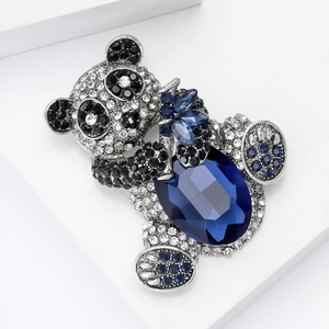 Macro shot of silver panda brooch featuring a large oval blue crystal and pavé rhinestones
