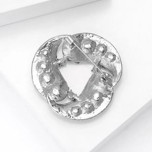 Close-up of the silver-plated brooch back view showing the metal safety pin clasp mechanism