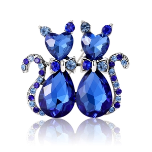Elegant twin cat brooch with heart and teardrop shaped blue crystals on silver base