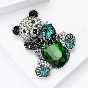 Macro detail of panda brooch featuring silver metal, black and white crystals, and green gem
