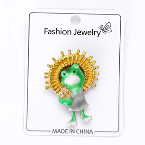 Détail de la broche grenouille en émail vert avec auréole dorée sur support bijoux