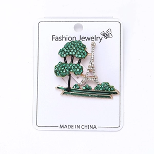 Detail of Eiffel Tower and green tree brooch featuring sparkling rhinestones on card