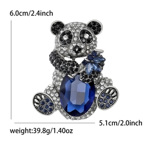 Fashionable panda brooch with large blue crystal centerpiece and pave-set rhinestones