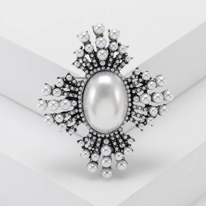 Vintage silver starburst brooch with large central pearl and radiating pearl accents