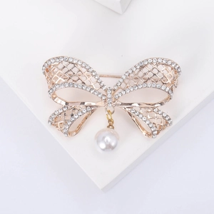 Broche élégante en forme de nœud ajouré en or rose avec cristaux et perle blanche
