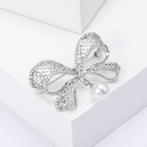 Broche nœud élégante ajourée avec strass scintillants et pendentif en perle blanche