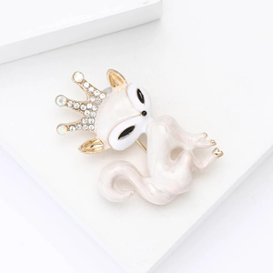 Détail de la broche renard en émail blanc avec couronne dorée et strass étincelants