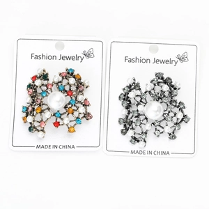 Detailed macro view of vintage brooches with colorful rhinestones and white pearls on display