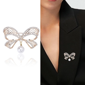 Broche nœud en maille creuse avec strass étincelants et un pendentif perle blanche ronde