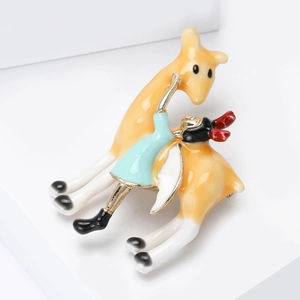 Détail macro de la broche en émail avec une fille et une girafe sur une base en alliage