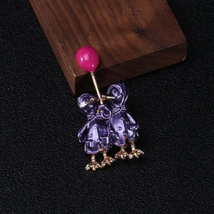 Detail of creative enamel duck brooch featuring two purple birds with a pink balloon