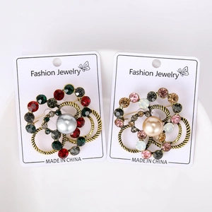 Close-up of vintage flower brooches with colorful rhinestones and pearls on gold base