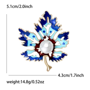 Broche feuille d'érable dorée avec émail bleu dégradé et perle sur fond blanc uni