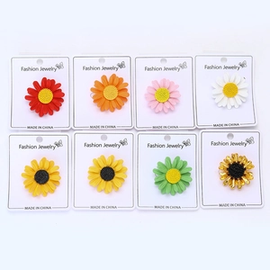 Ensemble détaillé de huit broches marguerites en émail coloré sur porte-bijoux
