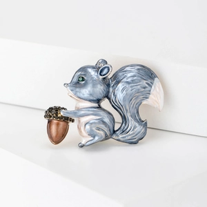 Charmante broche écureuil en émail avec queue bleue et gland brillant sur escalier