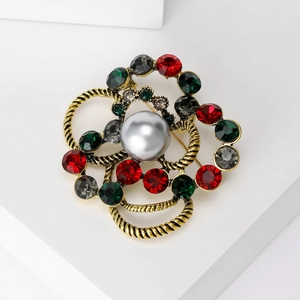 Macro detail of a vintage floral brooch featuring twisted gold rings and colorful rhinestones