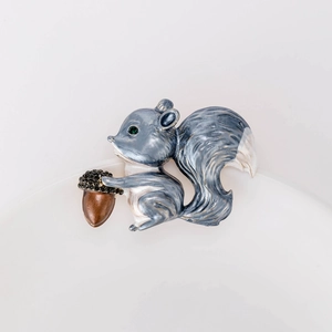 Vue détaillée de la broche écureuil émaillée avec glaçage bleu-gris et strass incrustés