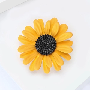 Détail d'une broche tournesol avec pétales jaunes mats et centre noir texturé fin