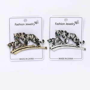 Detailed close-up of gold and silver tiger brooches with sparkling crystals and enamel