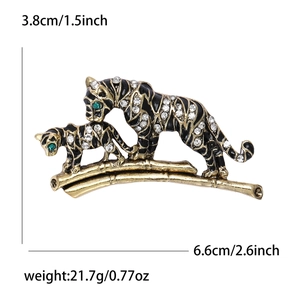 Tiger animal brooch with white rhinestones and green eyes on golden bamboo branch