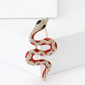 Broche serpent vintage en émail rouge et strass blancs sur un socle géométrique blanc